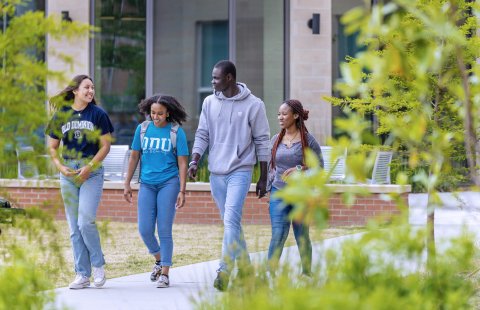 A group of students walking in front of Owens House residence hall